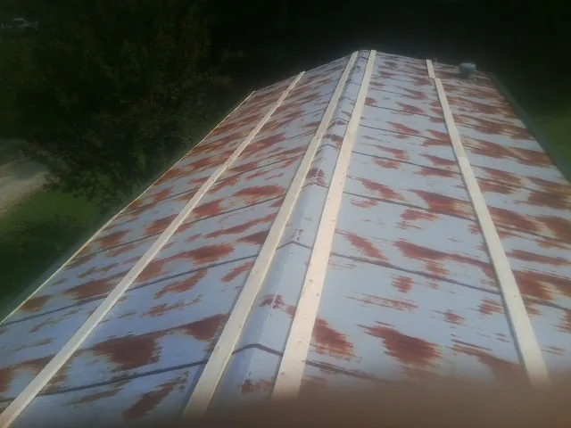 Rusted metal roof panels with new wood purlins before replacement — Storm Damage Roof Repair in Huntingdon by Roofing Brothers