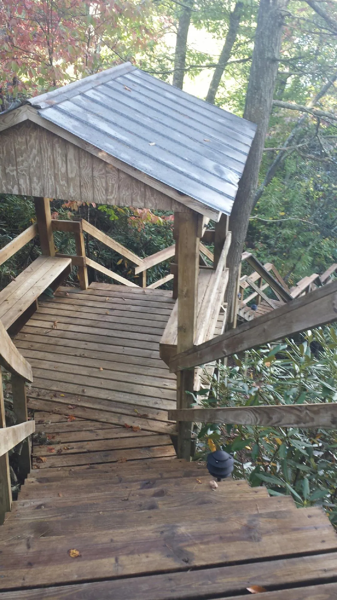 Metal roofed shelter over wooden steps on a wooded walkway — Skylight Repair & Installation work by our crew in Huntingdon