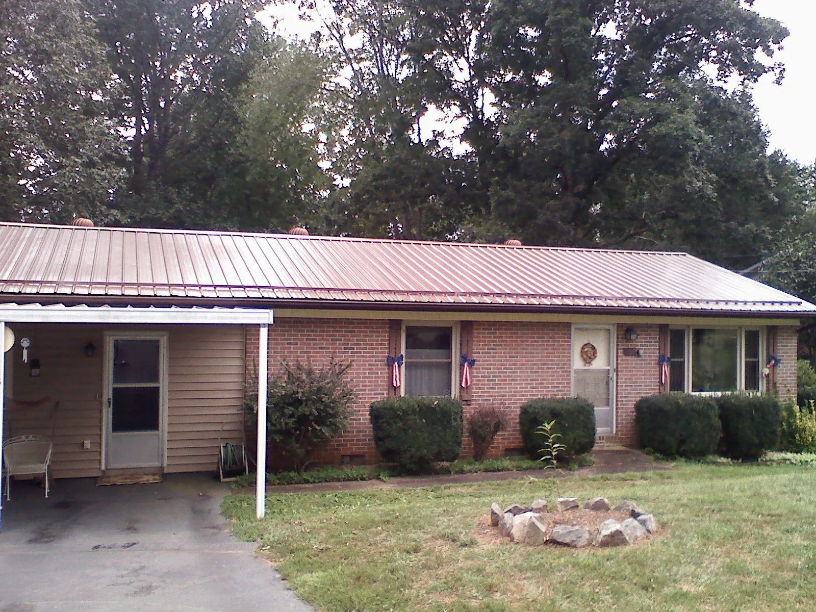 Bronze metal roof and carport on a brick ranch home — Roof Repair work by our crew in Huntingdon